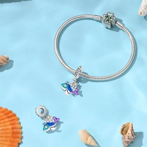 Détail du bracelet en argent avec breloques de baleine en émail violet et décor de coquillages