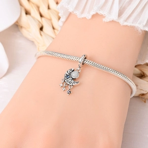 Silver snake chain bracelet featuring a crescent moon charm with blue and white zircons