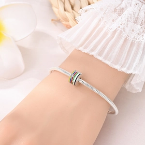 Detalle de dije de fútbol en esmalte arcoíris en pulsera de cadena de serpiente de plata