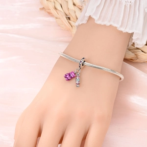 Silver snake chain bracelet featuring purple gummy bear and colorful candy charms on wrist