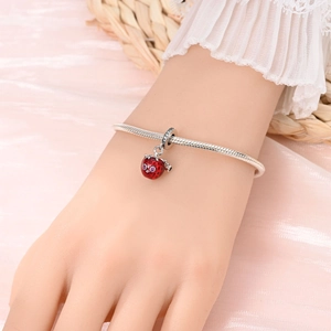 Silver snake chain bracelet featuring a red enamel ladybug charm with pink crystal inlay