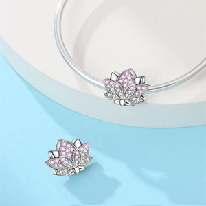 Detail of silver lotus charm bead with pink and white stones on a bracelet