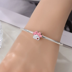 Détail du bracelet argenté avec breloque patte en émail rose et inscription Love gravée