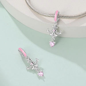 Detailed view of silver charm with pink enamel heart and faceted drop stone