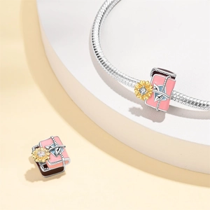 Macro view of S925 silver sunflower charm with pink enamel and sparkling zircon stone