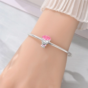 Detailed close-up of a silver charm bracelet with a pink floral bouquet and Love engraving