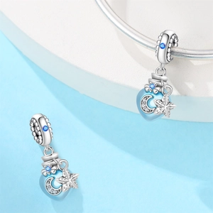 Macro detail of silver lobster and moon star charms with blue stones for bracelets