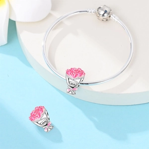 Detail of silver-plated snake chain bracelet with pink enamel flower bouquet charms