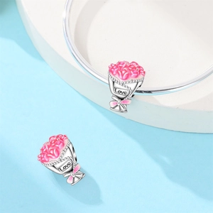 Detailed view of silver flower bouquet charm with pink enamel and Love engraving