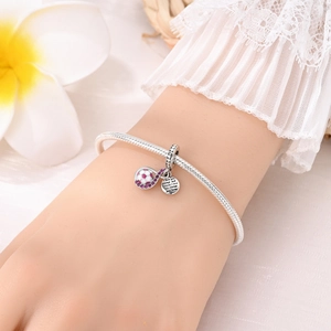 Primer plano del dije de fútbol plateado con cristales rosas y grabado en pulsera de plata