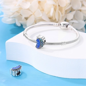 Detail of silver snake chain bracelet with blue enamel leaf charm and zircon inlay