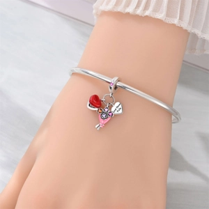 Detail of silver bracelet with Love Never Fails charm and pink floral enamel pendant