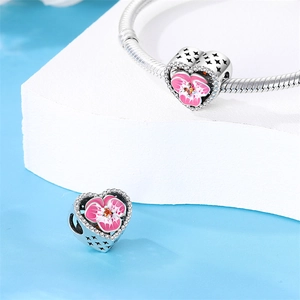 Detail of silver heart charm with pink enamel flower and white cubic zirconia accents