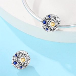 Macro shot of silver sun moon charm with blue and yellow zircon inlay for DIY bracelets
