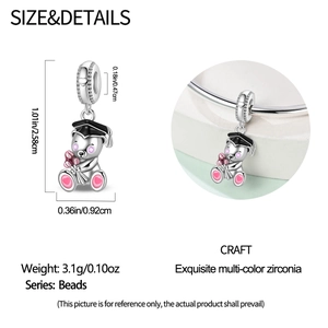Macro detail of silver graduation bear charm with black cap and pink flowers for bracelets