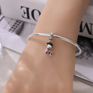 Detail of silver graduate bear charm with black cap and pink bouquet on open bangle