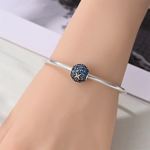 Silver open bangle with deep blue starry night charm and sparkling blue zircons