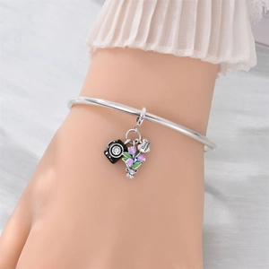 Silver charm bracelet featuring camera and tulip charms with Good record engraving