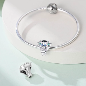 Detailed view of graduation bear charm with colorful stones on silver snake chain bracelet