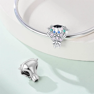 Close-up of silver graduation bear charm with colorful stones and academic cap