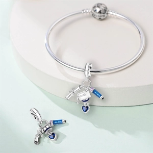 Detailed view of silver graduation charm with mortarboard cap and Graduate inscription