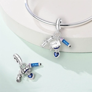 Macro view of silver graduation charm with Graduate engraving, blue zircon heart and enamel
