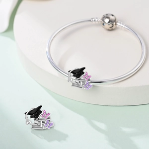 Macro view of graduation charm with black mortarboard and purple zircon butterflies