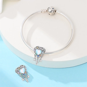 Detailed macro view of S925 silver charm bracelet with blue heart dreamcatcher pendants