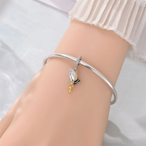 Silver bangle bracelet featuring a praying hands pendant with dollar sign and hat detail