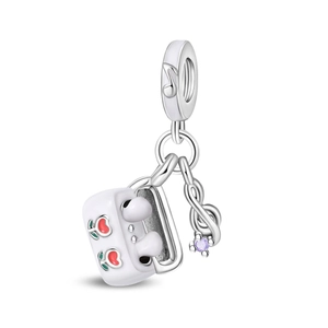 Detailed close-up of a silver music charm with headphone case, cherry enamel, and zircon