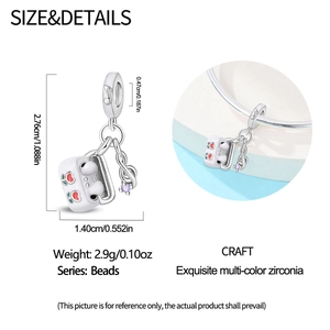 Detailed view of silver headphone charm with cherry enamel and purple zircon music note