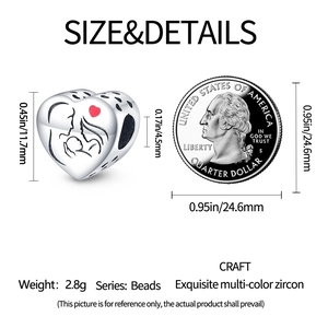 Abalorio de corazón de plata con grabado junto a moneda para comparar el tamaño real
