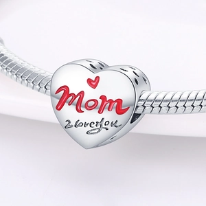 Primer plano de dije de corazón plateado con grabado rojo Mom e I love you en pulsera