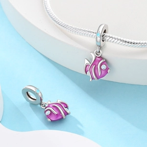 Détail d'un charme poisson tropical en émail violet avec zircon bleu sur un bracelet