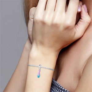 Dettaglio del ciondolo a coda di sirena argentato con smalto sfumato su un bracciale