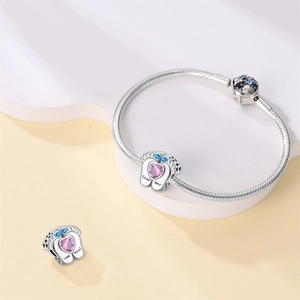 Detalle de pulsera de plata con dije de huella de bebé y circonita rosa en forma de corazón