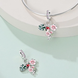Detail of silver flamingo and tropical leaf charms with pink zircon on a bracelet