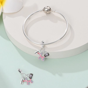 Detail of silver snake chain bracelet with balloon dog charm and LUCKY tag