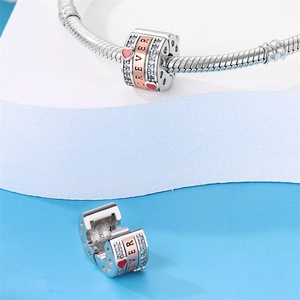 Vista macro charm in argento S925 con cuore smaltato rosa e anello Forever in oro rosa