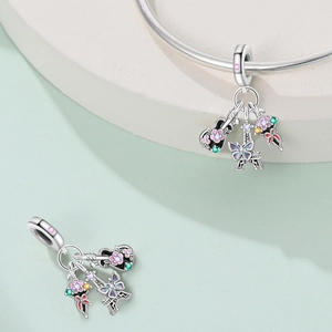 Detailed silver charms with guitar and Eiffel Tower motifs featuring colorful enamel