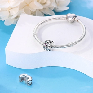 Dettaglio charm in argento S925 con petali di fiori bianchi e zirconi colorati