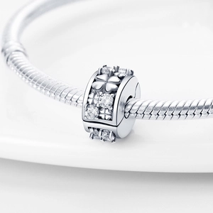 Charm quadrifoglio in argento con zirconi montato su un bracciale snake chain