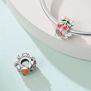 Detail von Fruchtanhängern mit Emaille-Kirsche und Wassermelone auf Silberarmband