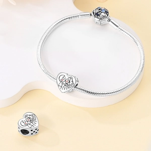 Detail of silver snake chain bracelet with heart wedding charm and blue gemstone clasp