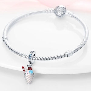 Vue macro d'un pendentif crème glacée en argent et cristaux sur bracelet maille serpent