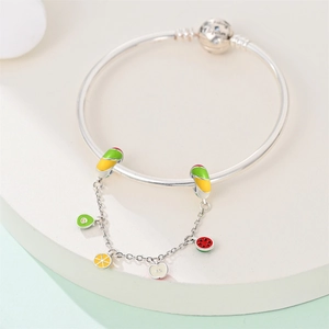 Dettaglio dei ciondoli alla frutta e clip smaltate sul bracciale in argento