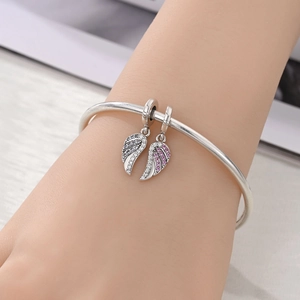 Silver feather wing charm bracelet featuring sparkling white and purple crystals