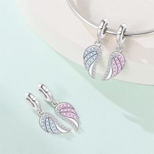 Detail of silver angel wing charms with pink and blue stones on a bracelet