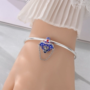 Detailed shot of silver bangle with red white and blue star heart and hat charms