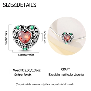 Detailed macro view of heart charm with red zircon inlay and green leaf accents